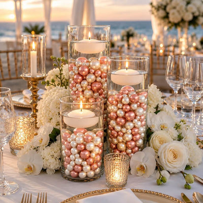 Floating candles in glass cylinders filled with rose gold and off-white pearls on a table setup - thumbnail number 2