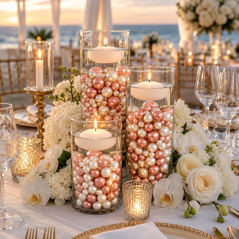 Floating candles in glass cylinders filled with rose gold and off-white pearls on a table setup - thumbnail number 2