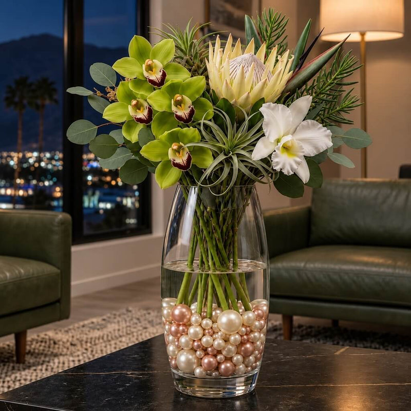 Tropical floral arrangement in a glass vase filled with rose gold and off-white pearl beads - thumbnail number 11