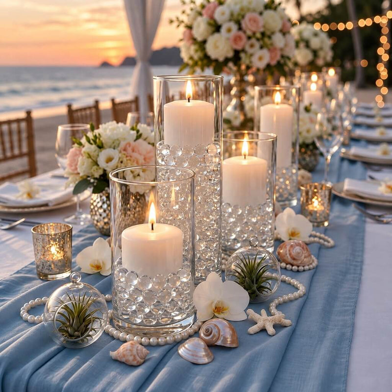 Glass cylinder vases filled with clear water gel beads and lit candles on a seaside table - thumbnail number 2