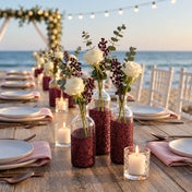 Glass vases decorated with metallic burgundy glitter and filled with flowers for beach wedding decor - thumbnail number 5
