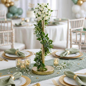 Gold metal stand wrapped in greenery with white floral centerpiece on a table setup - thumbnail number 4