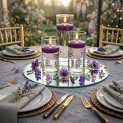 Three purple floating candles in glass cylinders on a mirrored tray with flowers - thumbnail number 4
