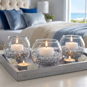 Lit candles in glass bowls filled with silver faux diamond gems on a tray in a cozy bedroom - thumbnail number 8