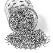 Sparkling silver faux diamond rhinestones spilling out of a glass jar onto a white background - thumbnail number 1