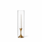 A white taper in a gold holder with a 4" x 16" chimney glass candle shade - thumbnail number 2