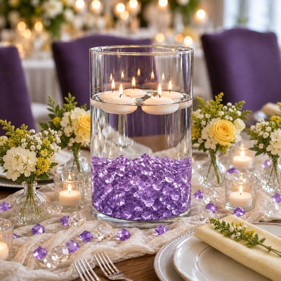 Floating candles in a glass cylinder with purple acrylic ice beads on a table setup - thumbnail number 4
