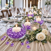 Lit white candles in glass bowls filled with purple acrylic ice beads on a table centerpiece - thumbnail number 5