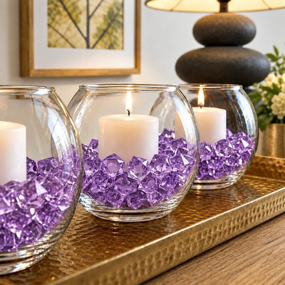 Lit candles in round glass bowls filled with purple acrylic ice beads on a golden tray - thumbnail number 7
