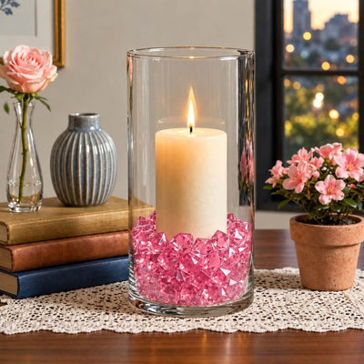 Lit white pillar candle in a glass cylinder filled with pink acrylic ice beads on a table runner - thumbnail number 8
