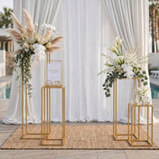 Two gold metal flower stands with floral arrangements on a woven rug - thumbnail number 6
