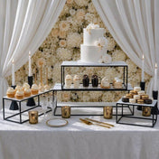 Elegant dessert display with a wedding cake, cupcakes, and macarons on black metal stands - thumbnail number 6