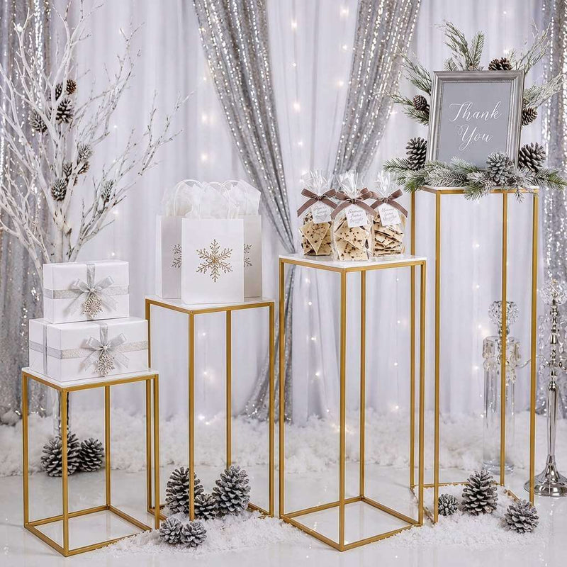 Gold stands with white acrylic tops displaying winter-themed favors before a silver backdrop - thumbnail number 6