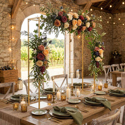 Gold metal arch stand over a rustic wedding table, decorated with rich floral arrangements and candles - thumbnail number 6