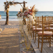 Gold metal mermaid tail flower stands line a beach wedding aisle - thumbnail number 4