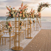 Gold metal floral risers lining a beach wedding aisle with peach and white flowers - thumbnail number 2
