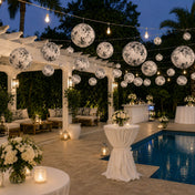 Black and white French toile paper lanterns hanging over a pool patio - thumbnail number 5