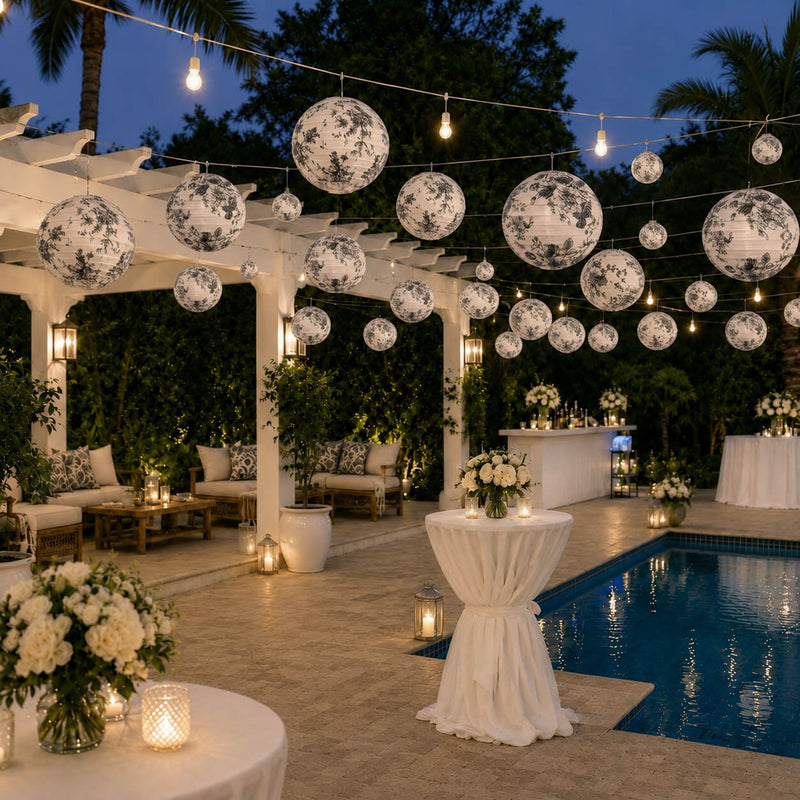 Black and white French toile paper lanterns hanging over a pool patio - thumbnail number 5