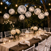 Black and white French toile paper lanterns hanging over outdoor dining table - thumbnail number 7