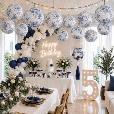 Blue floral paper lanterns hang above a blue and white birthday party setup - thumbnail number 2