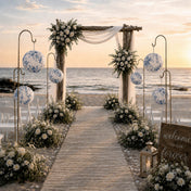 Blue floral paper lanterns hang on stands along a beach wedding aisle - thumbnail number 4