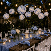 Blue floral paper lanterns hang above an outdoor rustic dinner party table - thumbnail number 7