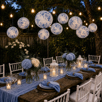 Blue floral paper lanterns hang above an outdoor rustic dinner party table - thumbnail number 7