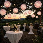Pink floral paper lanterns hang above a vineyard wedding reception - thumbnail number 6