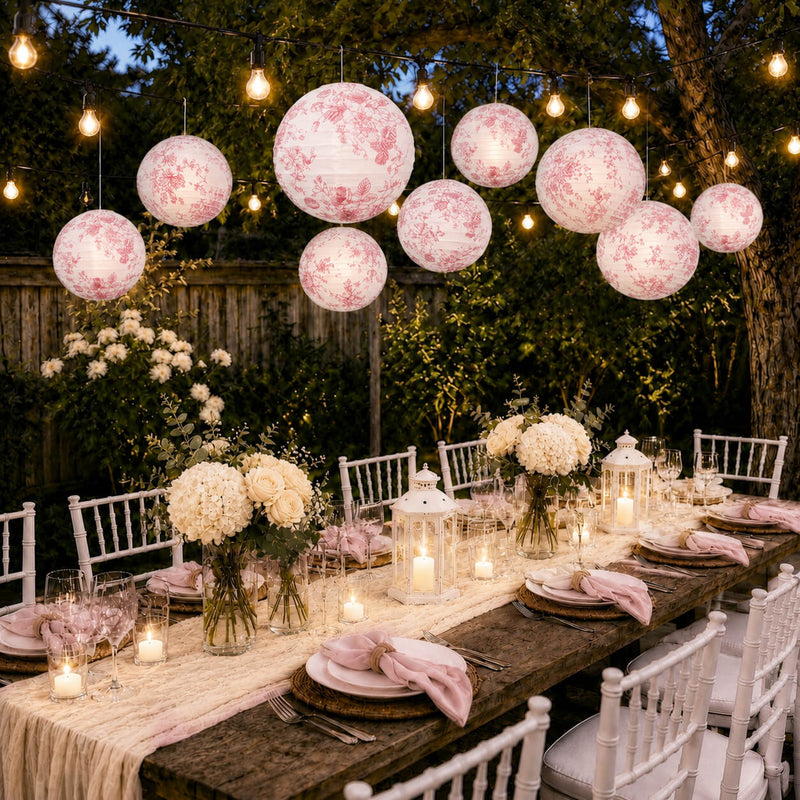 Pink floral French toile paper lanterns lit over an outdoor dining table - thumbnail number 7