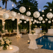 White and green toile paper lanterns hanging over a patio pool area - thumbnail number 5