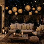 Hanging gold sequin lanterns and string lights illuminate an outdoor patio seating area at night - thumbnail number 2