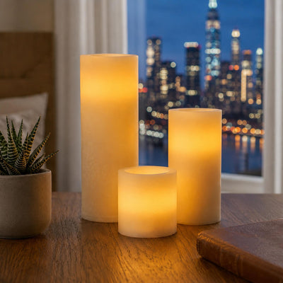 Three glowing flameless LED candles on wooden table by window with city lights at night - thumbnail number 6
