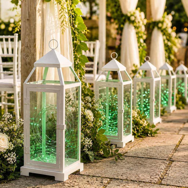 White lanterns filled with 20 LED green micro fairy string lights lining an outdoor wedding aisle - thumbnail number 4