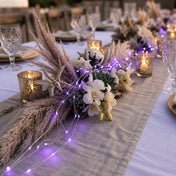 Purple LED fairy lights woven into a rustic table centerpiece with dried grass and candles - thumbnail number 6