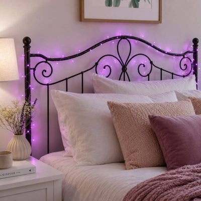 Purple LED fairy lights draped around a black metal headboard in a bedroom - thumbnail number 8