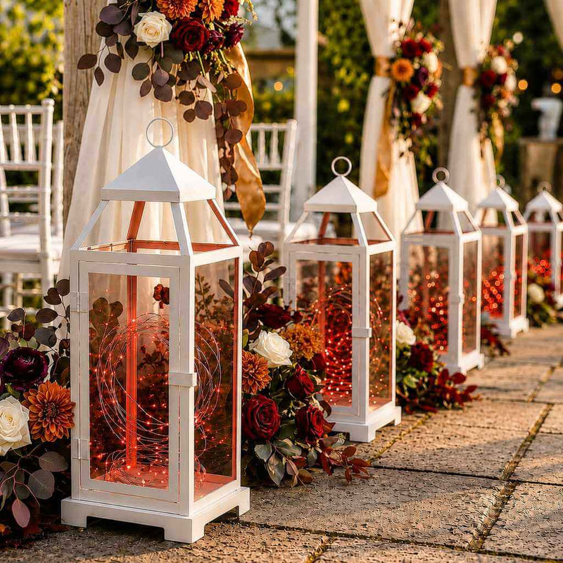 White lanterns with red LED fairy lights placed along an aisle with flowers - thumbnail number 4