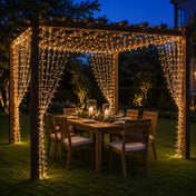 Warm white 300 LED icicle string lights draped over an outdoor dining pergola at night - thumbnail number 6