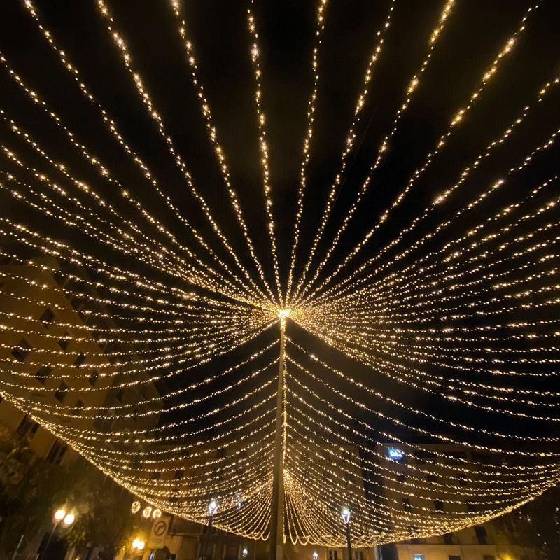 Illuminated string lights creating a starburst effect in a night scene. - thumbnail number 1