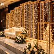 Warm white 192 LED icicle curtain fairy lights as a wedding backdrop behind a sofa - thumbnail number 5