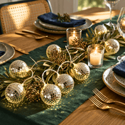 Disco ball string lights with candles and greenery decorating a formal dining table - thumbnail number 8