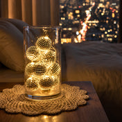 Disco ball string lights glowing inside a glass vase on a bedside table - thumbnail number 9