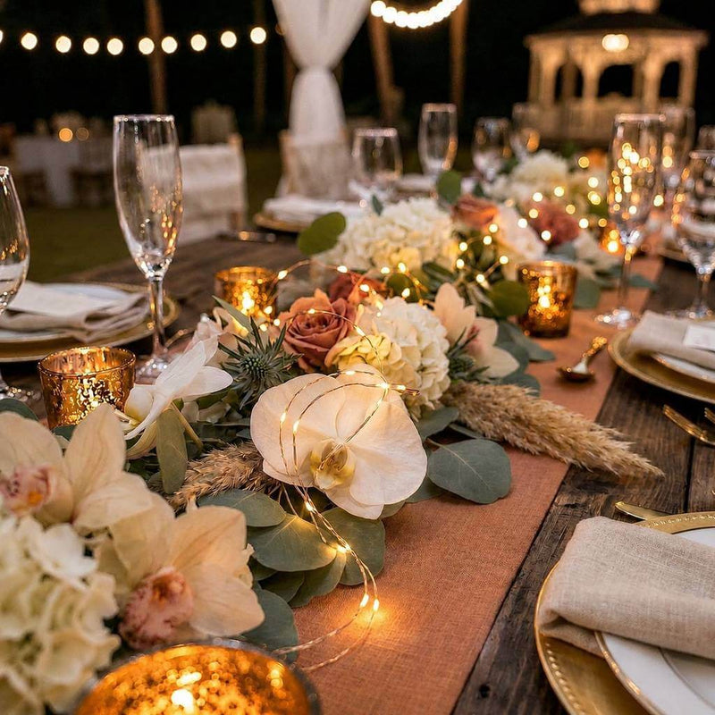 Wedding table runner with floral arrangements, gold votives, and fairy string lights - thumbnail number 6