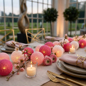 Pink and fuchsia cotton ball string lights decorate a dinner table with flowers and candles - thumbnail number 5
