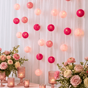 Pink and fuchsia LED cotton ball string lights hanging as a vertical backdrop behind flower bouquets - thumbnail number 6