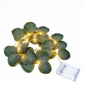 Coiled green eucalyptus leaf garland string lights lit up with a battery box - thumbnail number 2