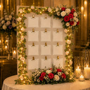 Rose and light garland framing a seating chart board with cards - thumbnail number 7