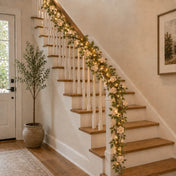 Rose and light garland draped down an indoor staircase banister - thumbnail number 10