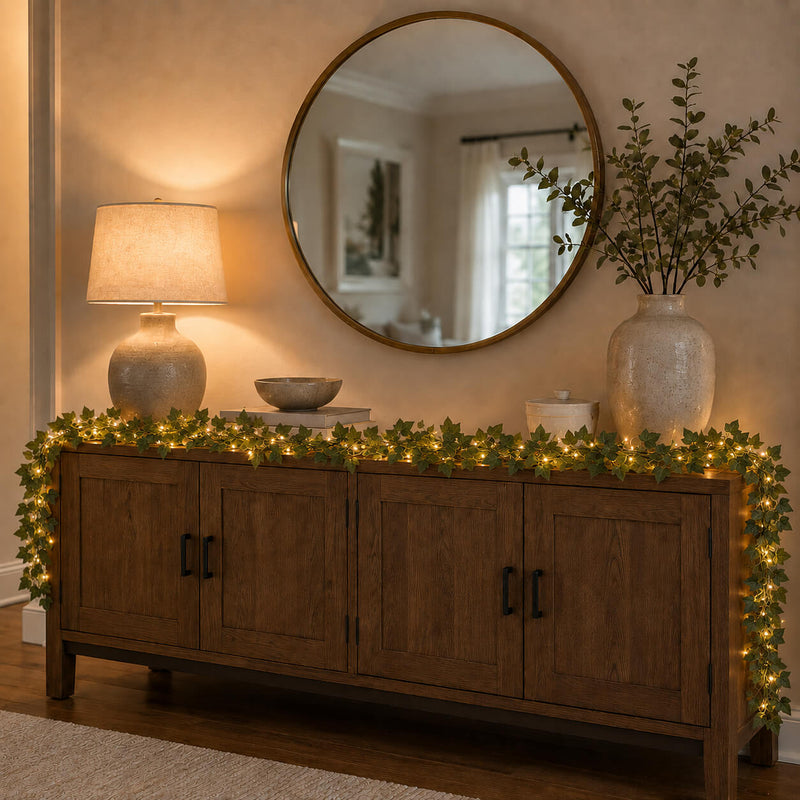 Ivy garland string lights draped along a wooden sideboard under a round mirror - thumbnail number 8