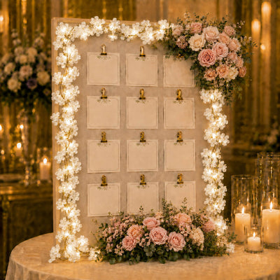 Cherry blossom garland string lights framing a wedding seating chart board - thumbnail number 6