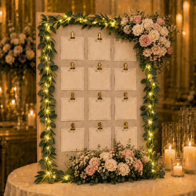 Eucalyptus garland with warm white LED string lights decorates a wedding seating chart board - thumbnail number 6